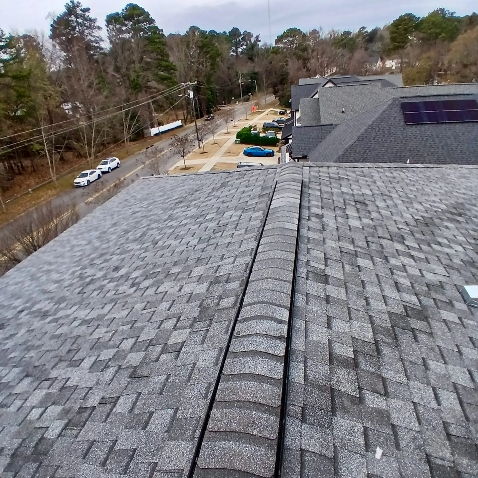 New shingle roof finished alongside a solar-panel section